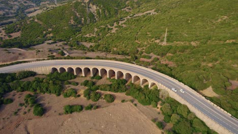 Tarifa-aerial-view-overlooking-traffic-driving-curved-Spanish-arched-hillside-highway