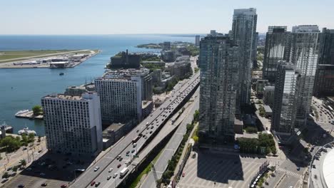 Drone-flying-along-the-Gardiner-Expressway-next-to-Lake-Ontario-and-Billy-Bishop-Airport-in-Toronto