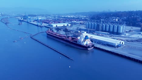 aerial-flyover-Ukrainian-cargo-ship-docked-loading-containers-full-of-supplies-from-Vancouver-pacific-port-and-back-to-Europe