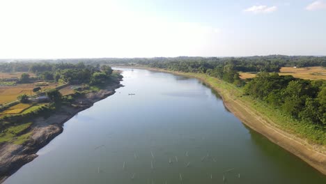 Aerial-view-of-the-breathtaking-Surma-River-surrounded-by-tree-filled-farmland