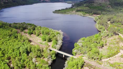 Aerial-upwards-reveal-shot-of-a-Loch-in-the-Scottish-Highlands-on-a-summers-day