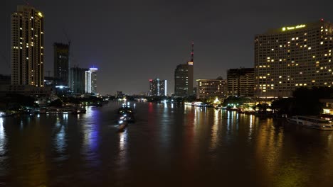 Bangkok-Stadt-Bei-Nacht,-Chao-Phraya-Taksin-Brücke,-Nächtlicher-Zeitraffer,-Nächtlicher-Starker-Bootsverkehr-Auf-Dem-Fluss