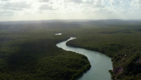 Tilt-down-aerial-drone-wide-shot-of-the-stunning-winding-Gramame-river-surrounded-by-exotic-foliage-near-the-tropical-beach-capital-city-of-Joao-Pessoa-in-Paraiba,-Brazil-on-a-warm-summer-day