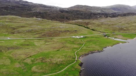 Aerial-panning-left-shot-of-a-Loch-Assynt-in-the-Scottish-Highlands-with-Mountains-in-the-background