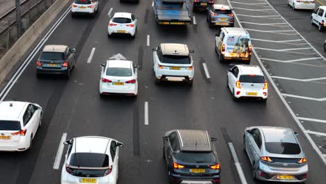 Workers-drive-in-busy-traffic-in-rush-hour-on-multi-lane-highway,-close-up-top-down-view