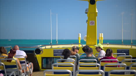 Slow-motion-of-a-view-of-the-top-deck-of-a-ferry-traveling-to-Isla-Mujeres-Mexico-on-a-sunny-day-with-people-enjoying-the-ride