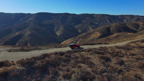 Epische-Luftaufnahme-Des-Roten-Offroad-Jeep-Kletterpfads-Auf-Wüstenhügeln