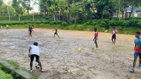 Entusiastas-Hombres-Asiáticos-Juegan-Un-Intenso-Partido-De-Mini-Fútbol-O-Fútbol-En-Un-Campo-Local-Fangoso