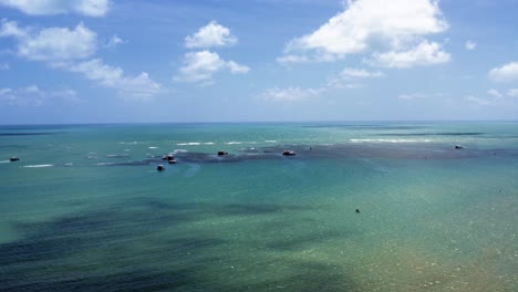 Aerial-drone-shot-of-the-famous-tourist-destination-of-the-Seixas-Natural-Pools-near-Cabo-Branco-in-the-beach-capital-city-of-Joao-Pessoa,-Paraiba,-Brazil-with-tour-boats,-kayaking,-and-snorkeling