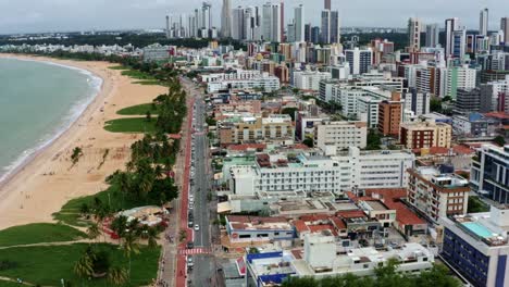 Tilting-up-dolly-in-aerial-drone-shot-of-the-cityscape-of-the-colorful-tropical-beach-capital-city-of-Joao-Pessoa-in-Paraiba,-Brazil-from-the-Tambaú-neighborhood-on-an-overcast-morning