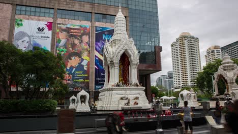 Busy-Buddhist-Hindu-Temple-Shrine-in-front-of-Modern-Shopping-Mall-in-Bangkok-Hyperlapse