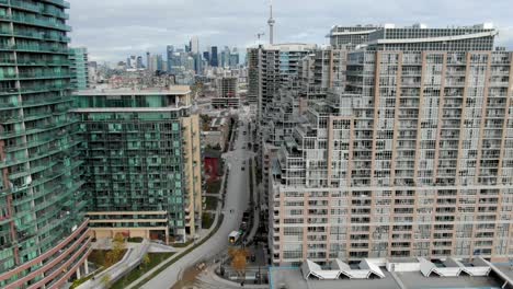Drohne-Fliegt-Von-Wohnhäusern-Mit-CN-Tower-Im-Hintergrund-In-Der-Innenstadt-Von-Toronto-Weg