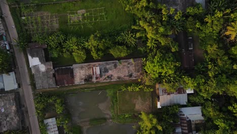 A-top-down-aerial-view-of-a-slum-house-surrounded-by-trees-in-Bangladesh,-highlighting-the-challenges-of-poverty-and-urbanization