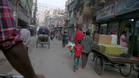 Vista-En-Primera-Persona-Desde-Un-Asiento-De-Pasajero-De-Rickshaw-Mientras-Un-Tirador-De-Rickshaw,-O-Conductor,-Recorre-Las-Calles-De-Dhaka