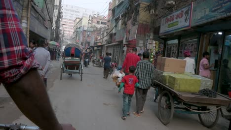 First-person-view-from-a-rickshaw-passenger-seat-as-a-rickshaw-puller,-or-driver,-rides-through-the-streets-of-Dhaka