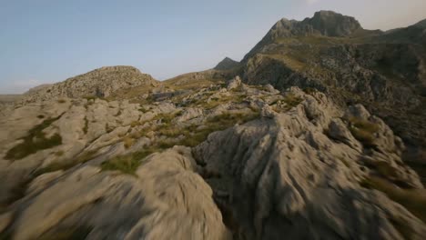 FPV-drone-forward-moving-shot-over-snake-road-along-rocky-mountain-range-in-Sa-Calobra,-Mallorca,-Spain-during-evening-time