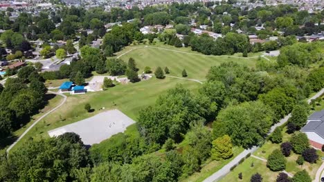 Drone-circling-over-green-space-with-a-basketball-court-in-London