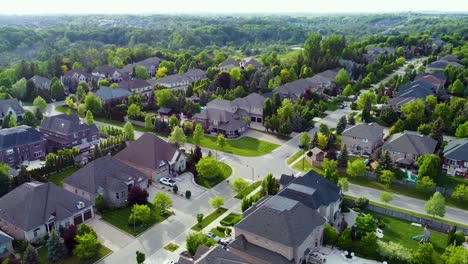 Orbiting-drone-shot-of-an-intersection-of-sunny-Kleinburg-houses