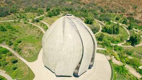 Aerial-orbit-of-the-Bahai-Temple-of-South-America,-curved-paths-of-the-wrap-around-garden,-Santiago,-Chile