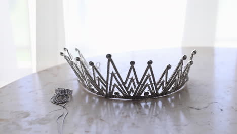 Silver-crown-and-bridal-jewelry-for-the-bride's-wedding-on-the-table---pan-right