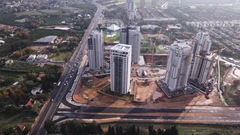 Panorama-Luftaufnahme-Von-Wolkenkratzern-Im-Bau-Mit-Blick-Auf-Die-Stadt-Und-Die-Autobahn,-Tel-Aviv,-Israel