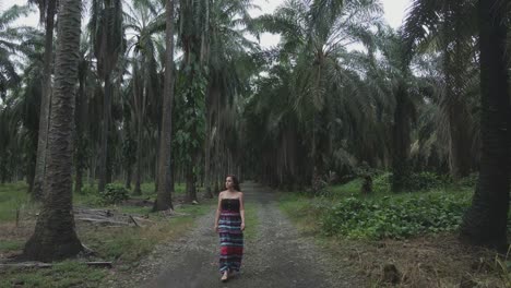 Cute-woman-with-long-hair-walking-in-street-between-palm-trees,-Costa-Rica