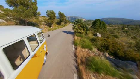FPV-aerial-flying-around-a-VW-Minibus-revealing-the-scenic-mountain-landscape-of-Catalonia,-Spain