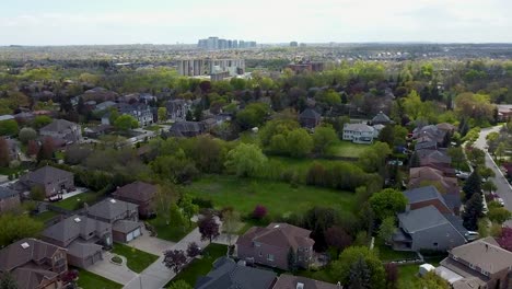 Aerial-view-flying-over-green-space-behind-neighborhood-houses-in-Mississauga