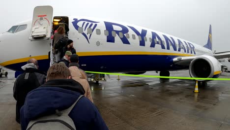 Passagiere,-Die-Im-Regen-Am-Internationalen-Flughafen-Brüssel---Belgien-In-Ein-Ryanair-Flugzeug-Einsteigen