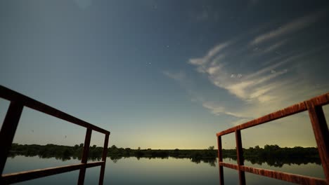 Night-time-lapse-of-stars-turning-into-sunrise-from-dock-overlooking-Texas-lake-in-summertime