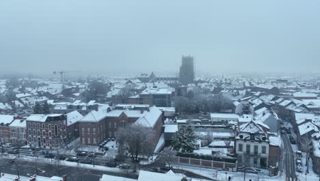 Snowfall-in-Tongeren,-Aerial-Dolly-In-City-Center-with-Basilica