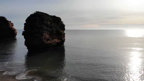 Langsame-Parallaxenaufnahme-Eines-Sandsteinstapels-Im-Meer-Vor-Der-Wunderschönen-Ladram-Bay-In-England-Bei-Sonnenuntergang