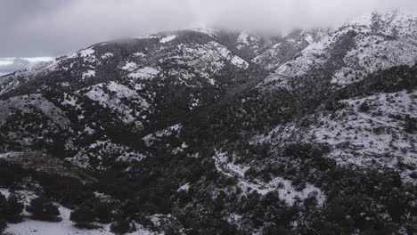 Striking-mountain-snowy-aerial-background,-drone-flies-into-wild-landscape