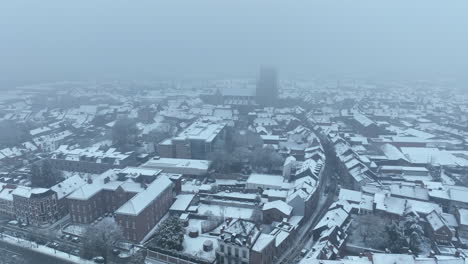 Aerial-Pullback-into-the-Clouds,-Disappearing-Tongeren-City-in-Snow