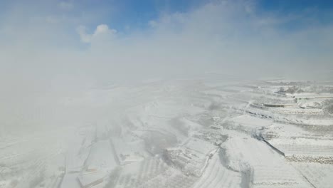 Aerial-view-pulling-back-of-village-and-terraced-farmland-after-snow-storm,-Israel