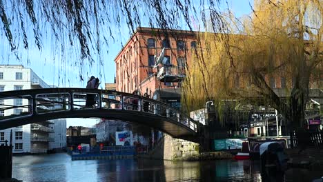 A-Close-up-view-of-those-on-the-Iron-footbridge-over-Regents-Canal-within-Camden,-London,-United-Kingdom