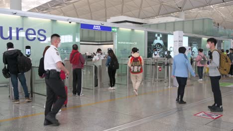Los-Pasajeros-Hacen-Cola-Para-Pasar-El-Control-De-Seguridad-En-La-Sala-De-Salidas-Del-Aeropuerto-Internacional-Chek-Lap-Kok-En-Hong-Kong,-China