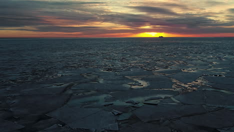 Aerial-View-Of-Ice-Floes-Floating-In-Sea-with-Sunset-in-Background
