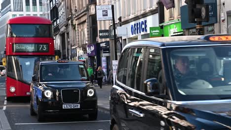 Multiple-Taxis-and-a-large-bus-heading-towards-Oxford-Circus,-London,-United-Kingdom