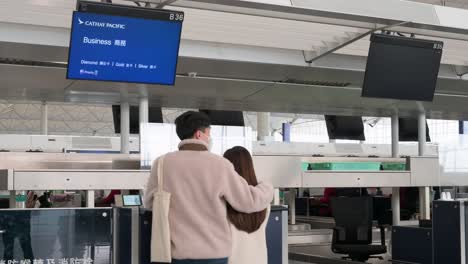 Flight-passengers-check-in-at-the-Cathay-Pacific-airline-desk-counter-in-Hong-Kong's-Chek-Lap-Kok-International-Airport