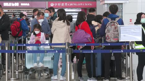 Reisepassagiere-Stehen-Schlange,-Um-Am-Schalter-Der-Fluggesellschaft-Am-Internationalen-Flughafen-Hongkong-Einzuchecken