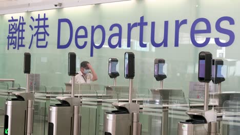 Ein-Sicherheitsmitarbeiter-Am-Flughafen-Wartet-Darauf,-Dass-Flugpassagiere-Durch-Die-Abflughalle-Des-Internationalen-Flughafens-Hongkong-Gehen