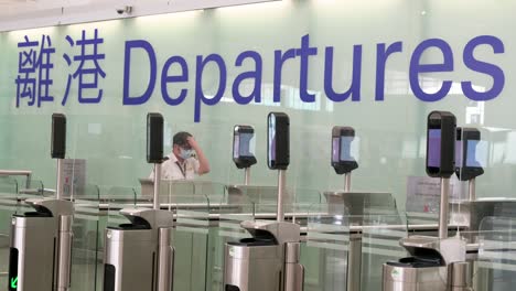 An-airport-security-worker-waits-for-flight-passengers-to-go-through-the-departure-hall-in-Hong-Kong-international-airport