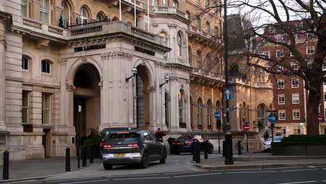 Multiple-Taxis-Driving-Past-The-Langham-Hotel-and-Spa,-London,-United-Kingdom