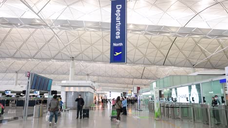 Reisepassagiere-Werden-In-Der-Abflughalle-Gesehen,-Während-Sie-Die-Sicherheitskontrolle-Am-Internationalen-Flughafen-Hongkong-Durchlaufen