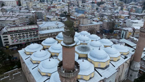 Grand-Mosque-Of-Bursa-Under-The-Fresh-Snow-In-Turkey---aerial-drone-shot