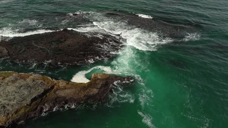Aerial-view-of-waves-crashing-onto-Northern-California's-rocky-coastline