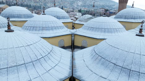 Domes-Of-Grand-Mosque-Of-Bursa-With-Snow-In-Turkey---aerial-drone-shot