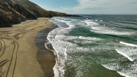 Luftaufnahme-Der-Sandküste-Kaliforniens-Mit-Weißen-Wellen,-Die-An-Die-Küste-Rollen