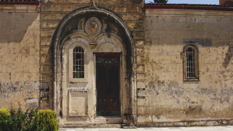Arco-De-Piedra-Sobre-Una-Antigua-Puerta-De-Madera-En-La-Pared-Del-Patio-Del-Monasterio-De-Motsamet